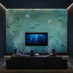 Fototapeta 3D z motywem oceanu na ścianie TV w nowoczesnym domowym kinie.