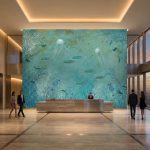 Fototapeta 3D z motywem oceanu i rafy koralowej na całą ścianę w nowoczesnym hotelowym lobby.